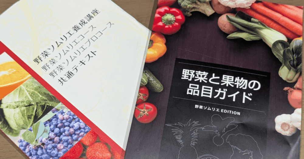 野菜ソムリエ養成講座の共通テキストと「野菜と果物の品目ガイド」。色とりどりの野菜や果物が表紙に並ぶ教材の写真