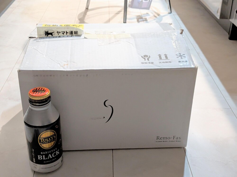 リモファスボックスと缶コーヒーを並べ、箱の高さと奥行きを側面から比較している写真。